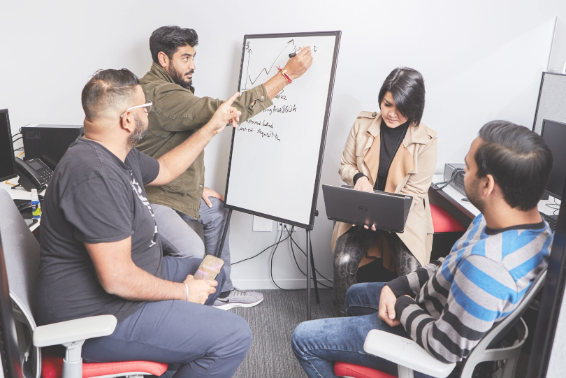 Four SetSchedule employees going over updates